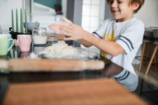 istock Kid in the kitchen, Cute son preparing the dough, bake cookies in the kitchen 1286638048