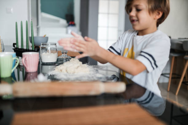 istock Kid in the kitchen, Cute son preparing the dough, bake cookies in the kitchen 1286638710