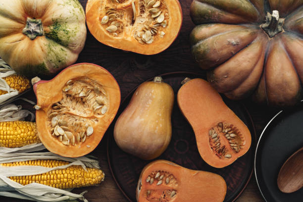 istock Corn cob and pumpkin on brown wooden board 1286643564