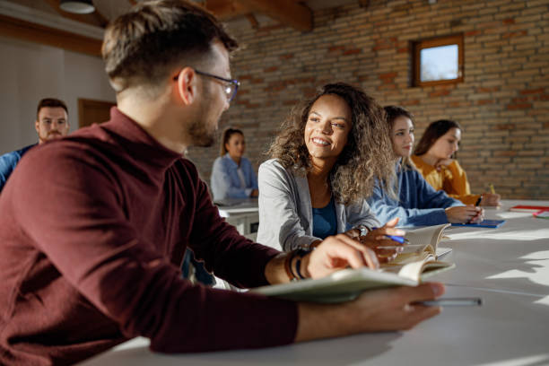 istock Happy university students talking on a class in the classroom. 1286643599