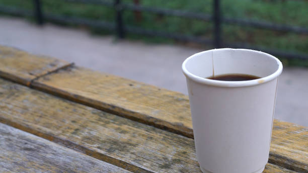 istock Hot coffee in white paper cup on rustic timber table 1286645039