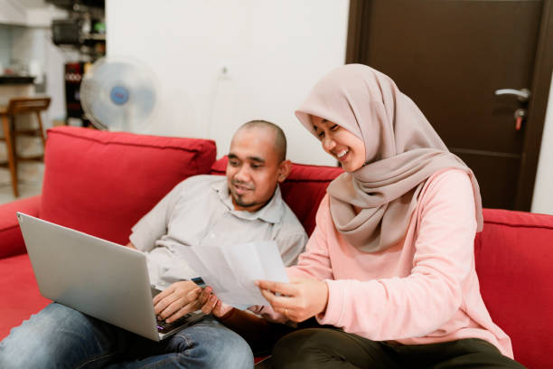 istock young asian couple using laptop to pay bill at home 1286645416