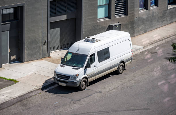 istock White compact popular cargo mini van standing on the city street with warehouse building 1286645648