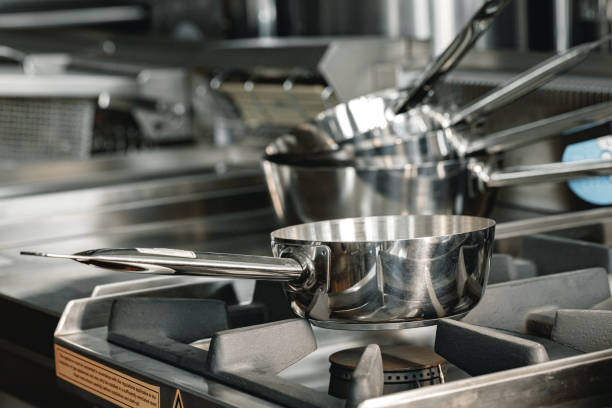istock Stacked industrial metal cooking pots on proffesional kitchen 1286647522