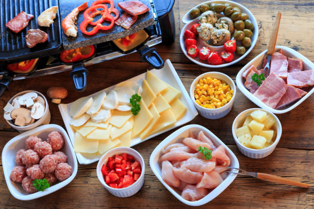 Raclette with vegetables, meat and cheese stock photo