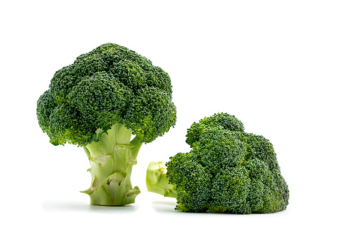 Close up isolated two Broccoli on white. One standing up, and on the left side one lying down.Selective focus