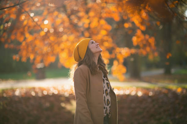 istock smiling stylish female in brown coat and yellow hat 1286654298