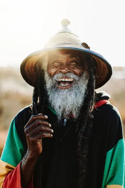 Portrait of old rastafari with dreadlocks smiling looking at the camera in the nature