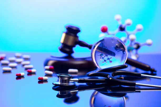 Gavel and stethoscope on the glass table. Blue light.