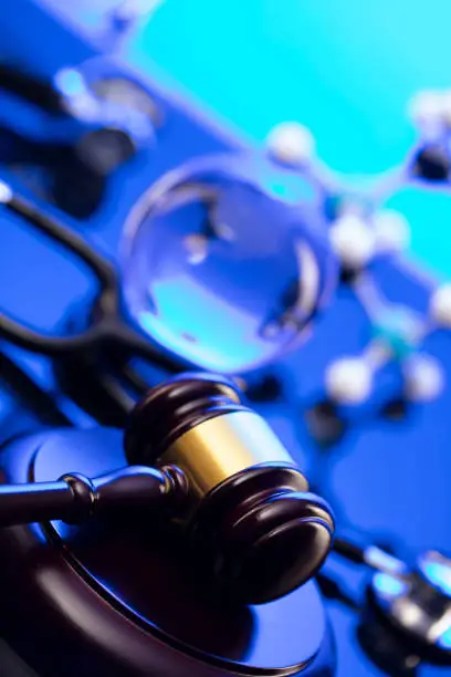 Gavel and stethoscope on the glass table. Blue light.