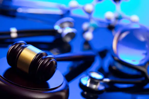 Gavel and stethoscope on the glass table. Blue light.