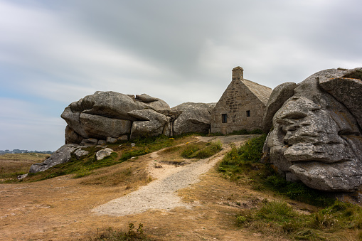 House between rocks in Meneham on the atlantic coast in northern Brittany (France), cloudy day in summer