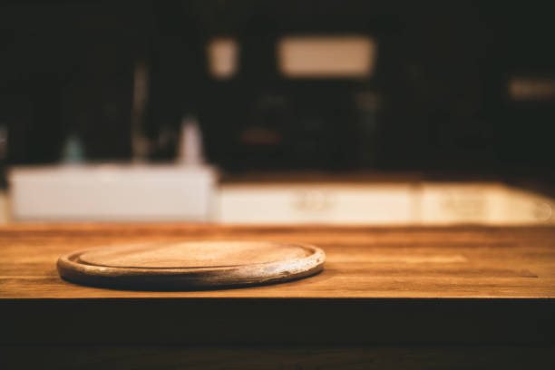 leere pizza-board auf dem tisch und küche innenhintergrund - wood bin stock-fotos und bilder