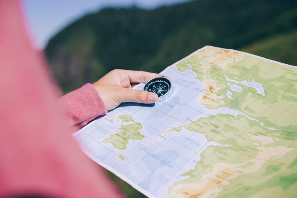 istock Hand of woman looking on map and compass to checking her position. 1286659008