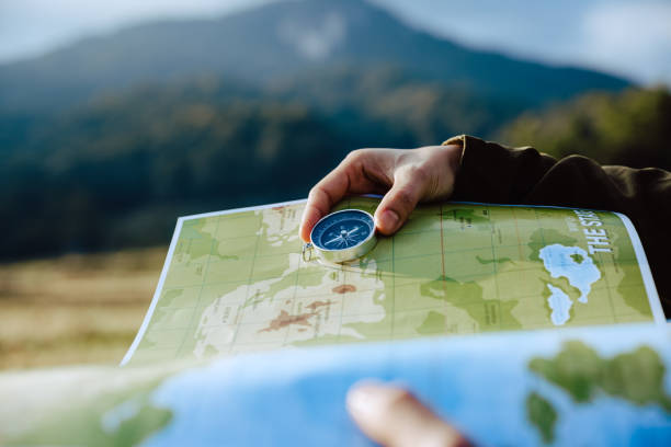 istock Hand of woman looking on map and compass to checking her position. 1286659046