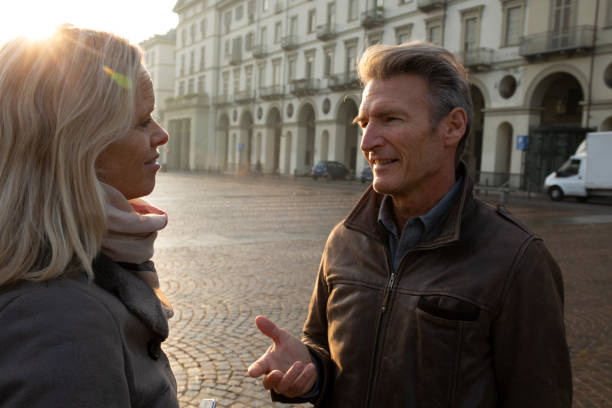 istock Mature couple walks down cobblestone street at sunrise 1286659079