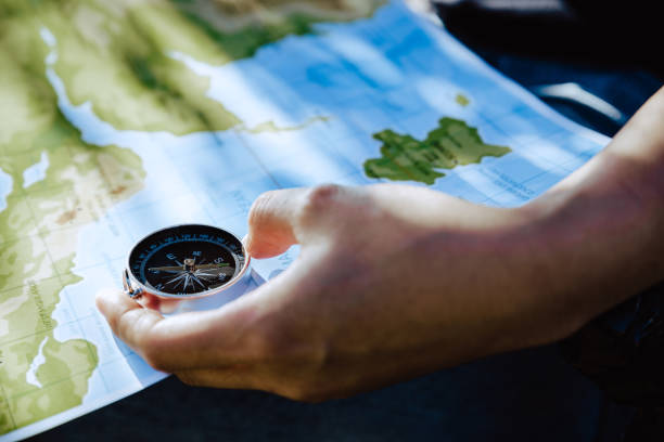 istock Hand of woman looking on map and compass to checking her position. 1286659089