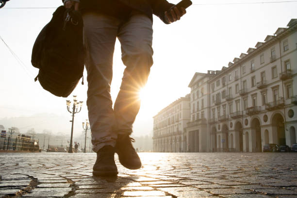 istock Businessman walks down cobblestone street at sunrise 1286659220