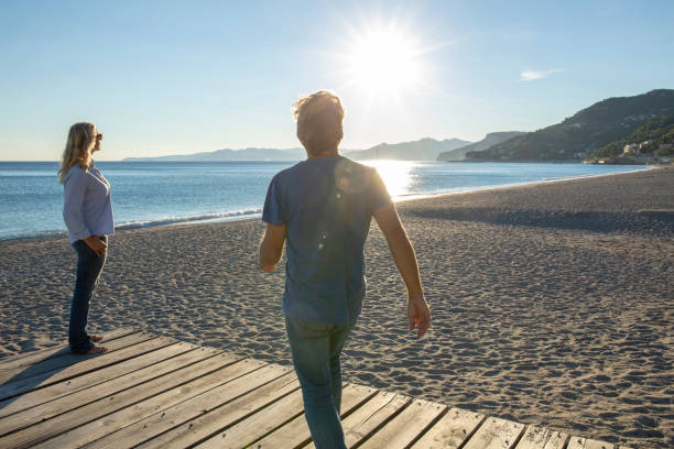 istock Mature couple relax by seaside at sunrise 1286659469