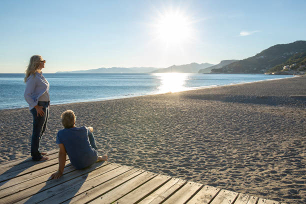 istock Mature couple relax by seaside at sunrise 1286659481