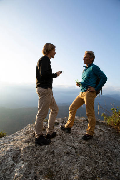 istock Hikers relax on mountain ridge at sunrise 1286660409