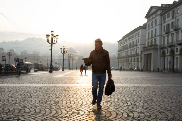 istock Man walks down cobblestone street at sunrise 1286660459
