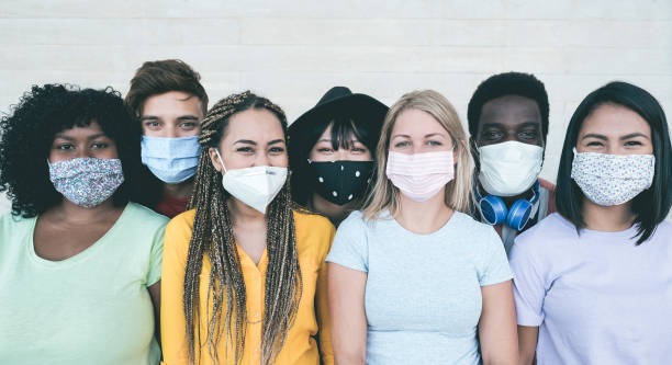 istock Young multiracial people wearing protective masks during coronavirus outbreak - Social distance between friends concept - Main focus on girl with yellow t-shirt face 1286660652