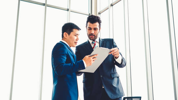 istock Two business people talk project strategy at office 1286663540