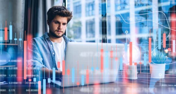 istock Businessman working at modern office.Technical price graph and indicator, red and green candlestick chart and stock trading computer screen background. Double exposure. Trader analyzing data 1286664722