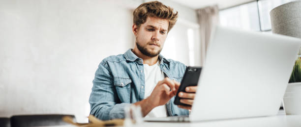 istock Young man with smartphone in his hands. Modern businessman at sunny office. Freelancer at work. 1286664756