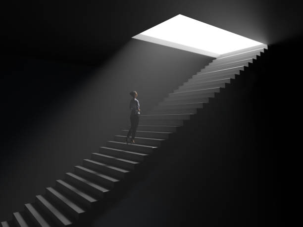 mujer sube las escaleras de la oscuridad a la luz - moody light fotografías e imágenes de stock