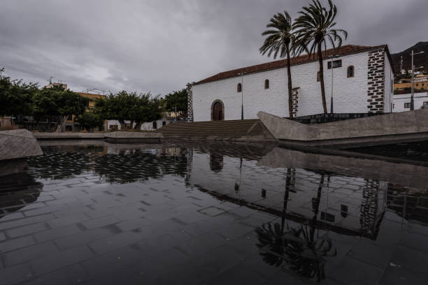 construction that is reflected on the wet ground of a public square in Adeje, Tenerife South stock photo