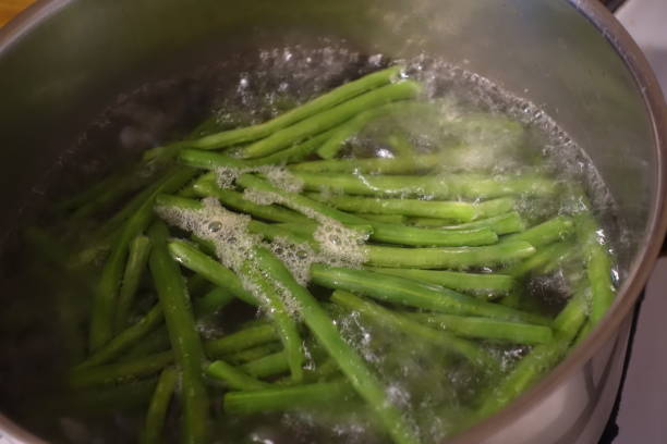 haricots verts étant cuits dans l’eau bouillante dans une casserole - greenbean casserole photos et images de collection