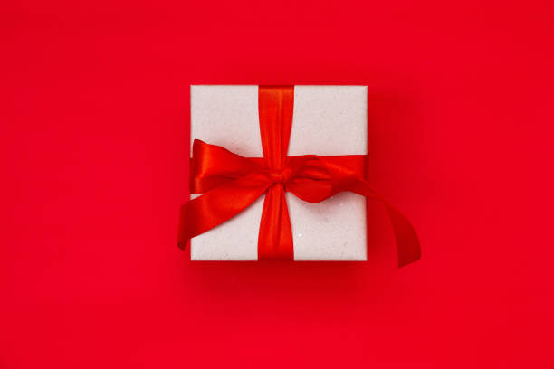 istock Gift box with a Christmas bow on a red background with copy space.Christmas composition. Flat lay, top view. Minimalistic style. 1286669605