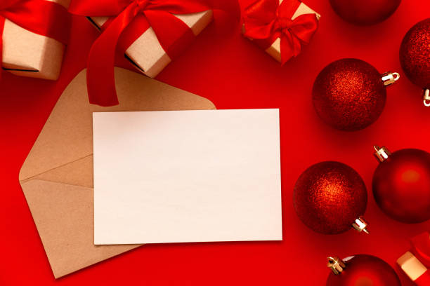 istock Blank paper sheet, mail envelope and red Christmas balls on a red background with copy space. New Year composition. Flat lay, top view. Minimalistic style. 1286669649