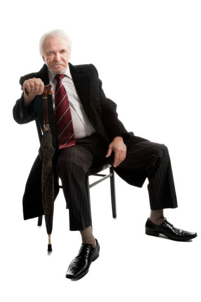 istock Elderly businessman in coat and with umbrella 1286674190