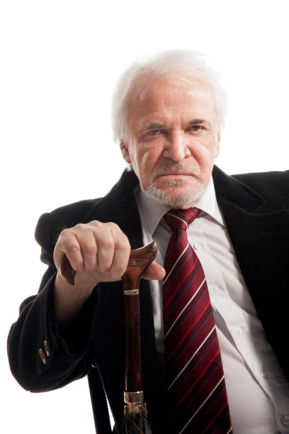 istock Elderly businessman in coat and with umbrella 1286674196