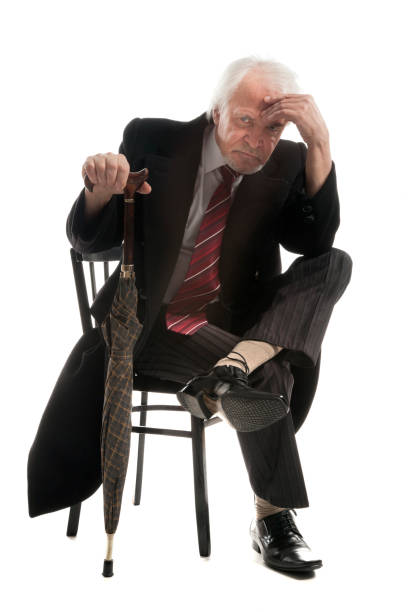 istock Elderly businessman in coat and with umbrella 1286674211