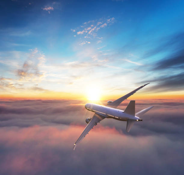 istock Commercial airplane flying above clouds in dramatic sunset light. 1286675685