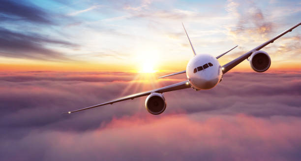 istock Commercial airplane flying above clouds in dramatic sunset light. 1286675691