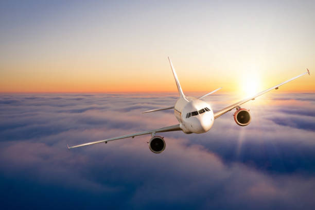 istock Commercial airplane flying above clouds in dramatic sunset light. 1286675704