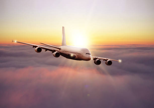 Commercial huge airplane flying above clouds in dramatic sunset light. Fast Travel and transportation concept