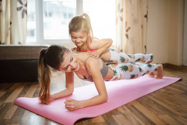 istock Mother and daughter exercising together at home. 1286677308