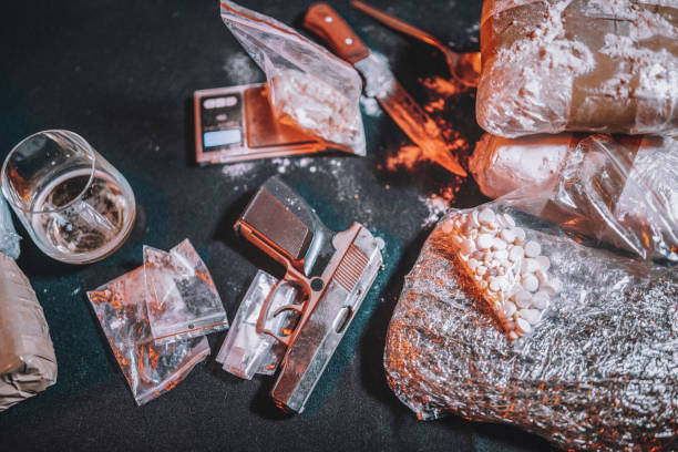 istock View of drugs and weapons on table. 1286677332