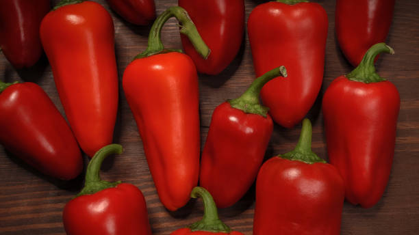 close up chillies or peppers and capsicums or bell peppers. sweet bell, paprika, cayenne, chilli, hungarian wax pepper, isolated on wooden table background - mexico chili pepper bell pepper pepper imagens e fotografias de stock