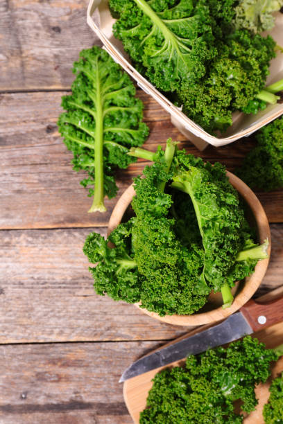 istock kale- green kale leaves on wooden table 1286682465