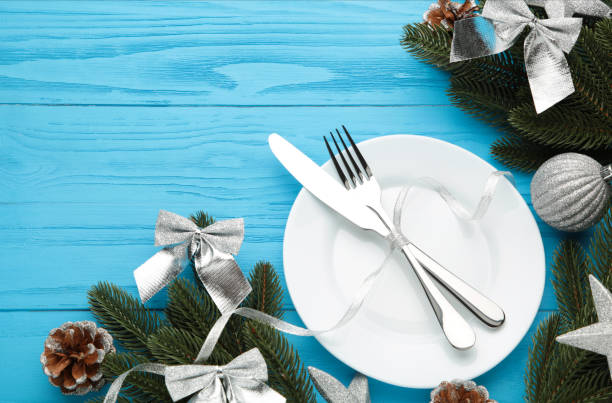 istock Christmas table place setting with blue and silver decoration on blue. Holidays background 1286682702