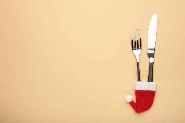 istock Creative concept photo of tableware in christmas hat on beige background. 1286682717