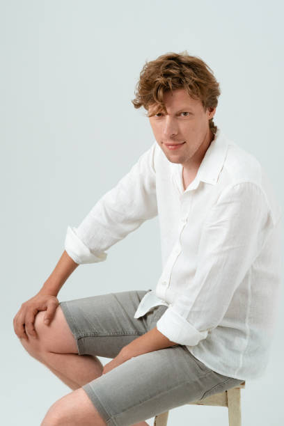 istock Sitting on chair young man looking at camera isolated on white background. Human emotions, facial expression concept. Facial expressions, emotions, feelings 1286682750