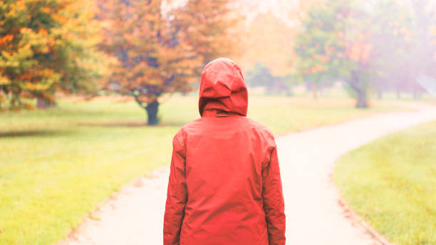 Hiker walking in a mystical forest with red coat.
